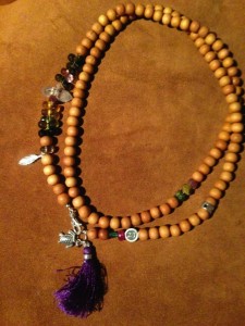 Necklace made with assorted gemstones and wood beads adorned with sterling silver animal charms and a purple tassel - animal totem jewelry